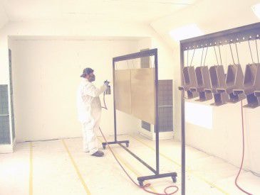 Painter applying wet spray coating in paint booth at Northstar Steel Fabricating